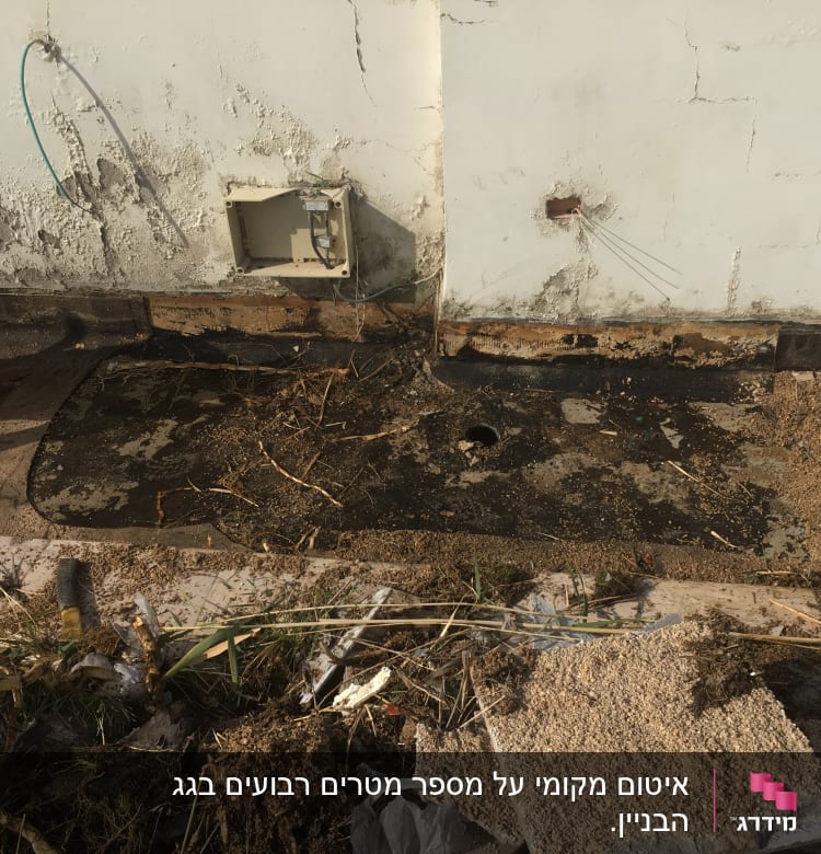 אדם מניח יריעת איטום על הקרקע ליד קיר